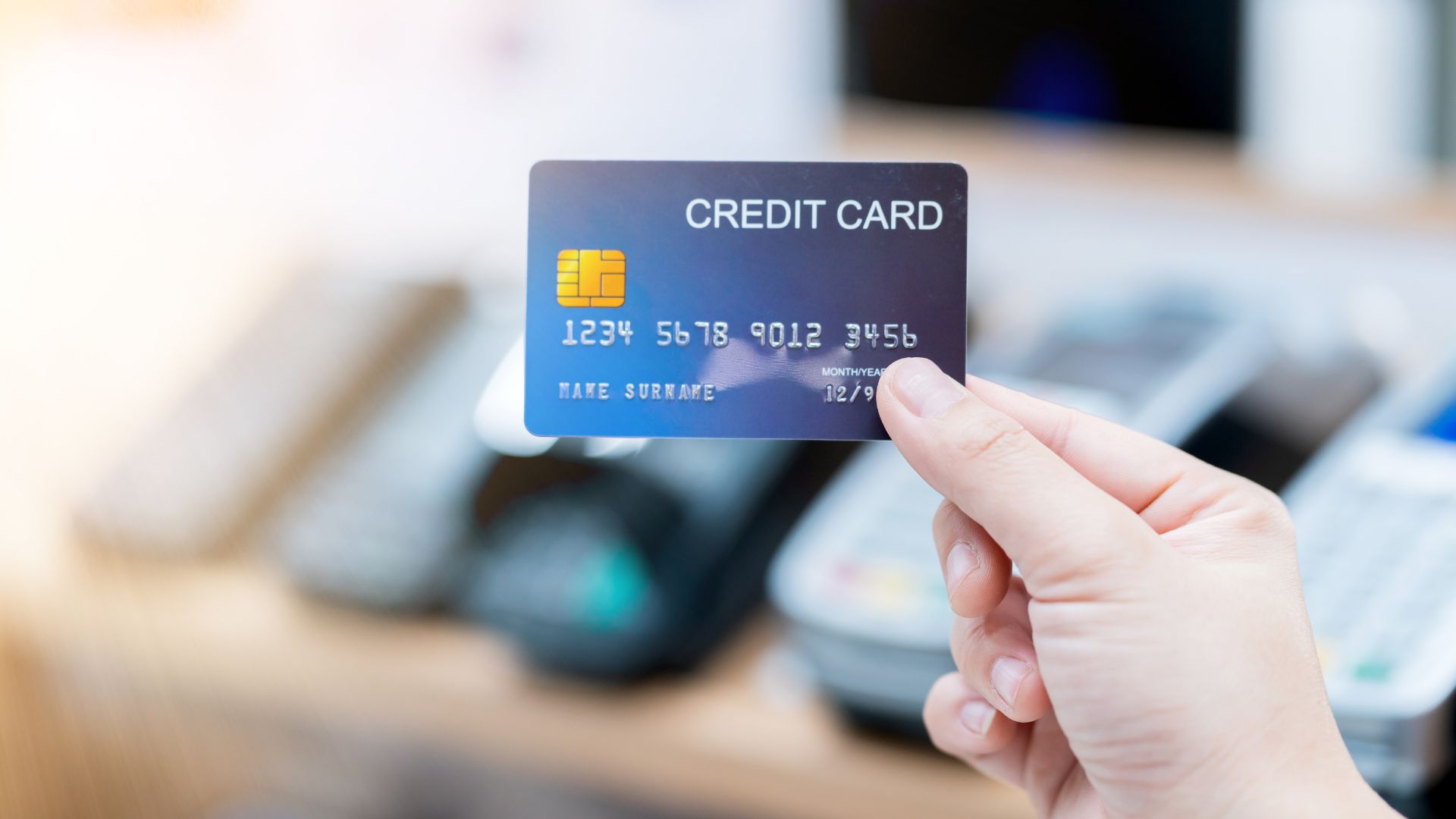 Person holding a credit card near a payment terminal – business credit card concept in Malaysia 2025.