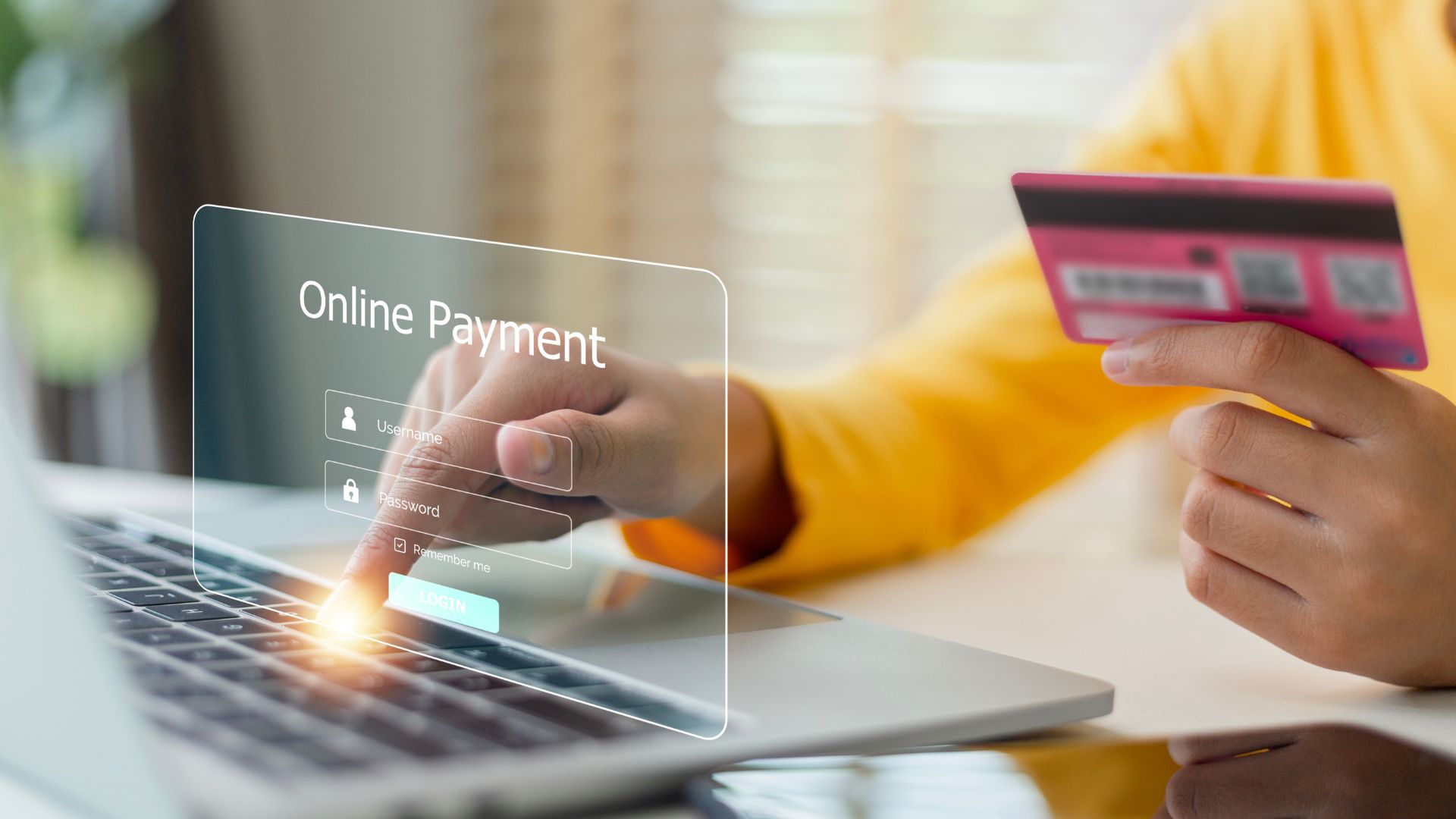 A person holding pink credit or debit card to fill up the online payment information needed.