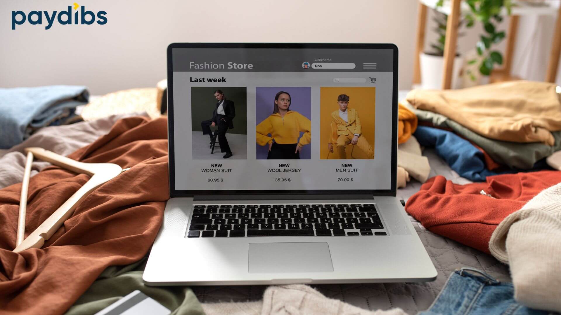 Paydibs branded image showing a laptop displaying an online fashion store with product listings, surrounded by folded clothes and hangers, representing eCommerce Shopify setup and online payment gateway integration for retail businesses.