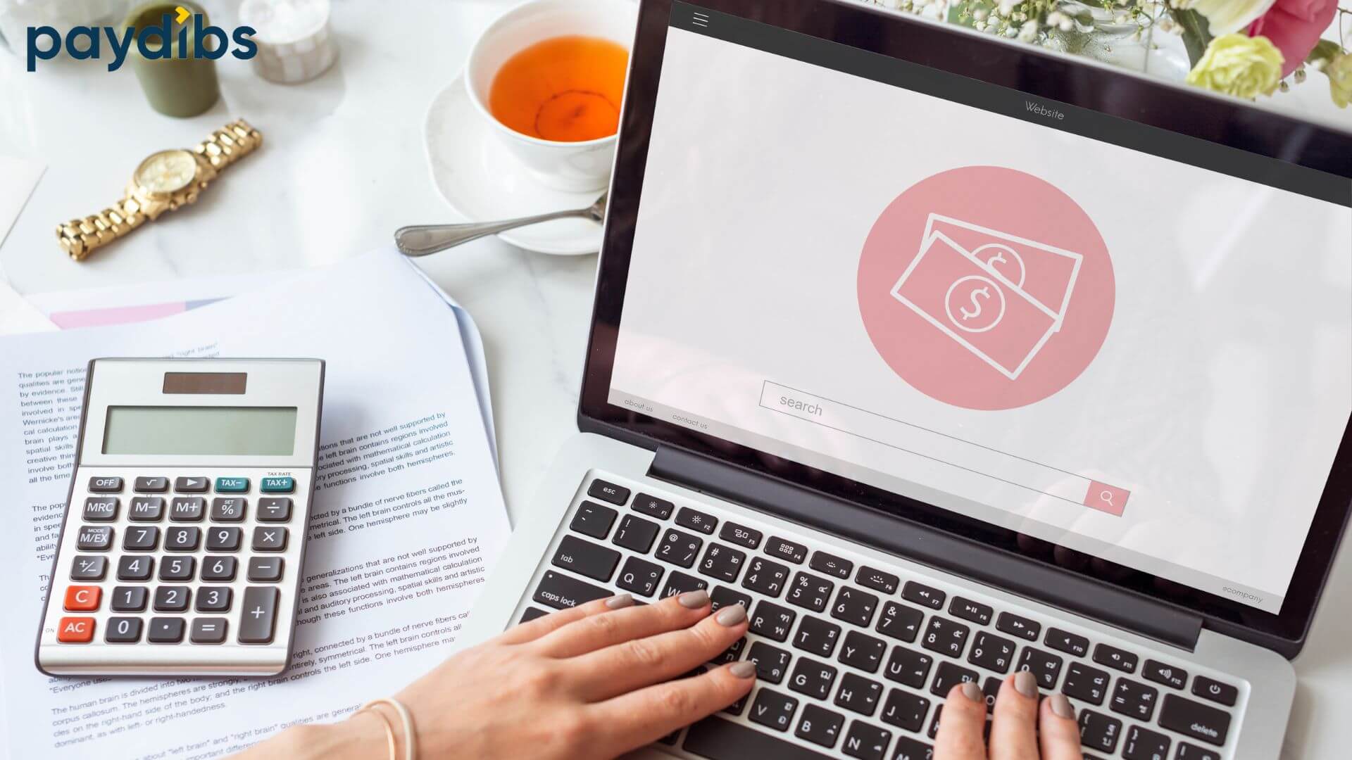 A hand with grey manicure typing on laptop with calculator beside it