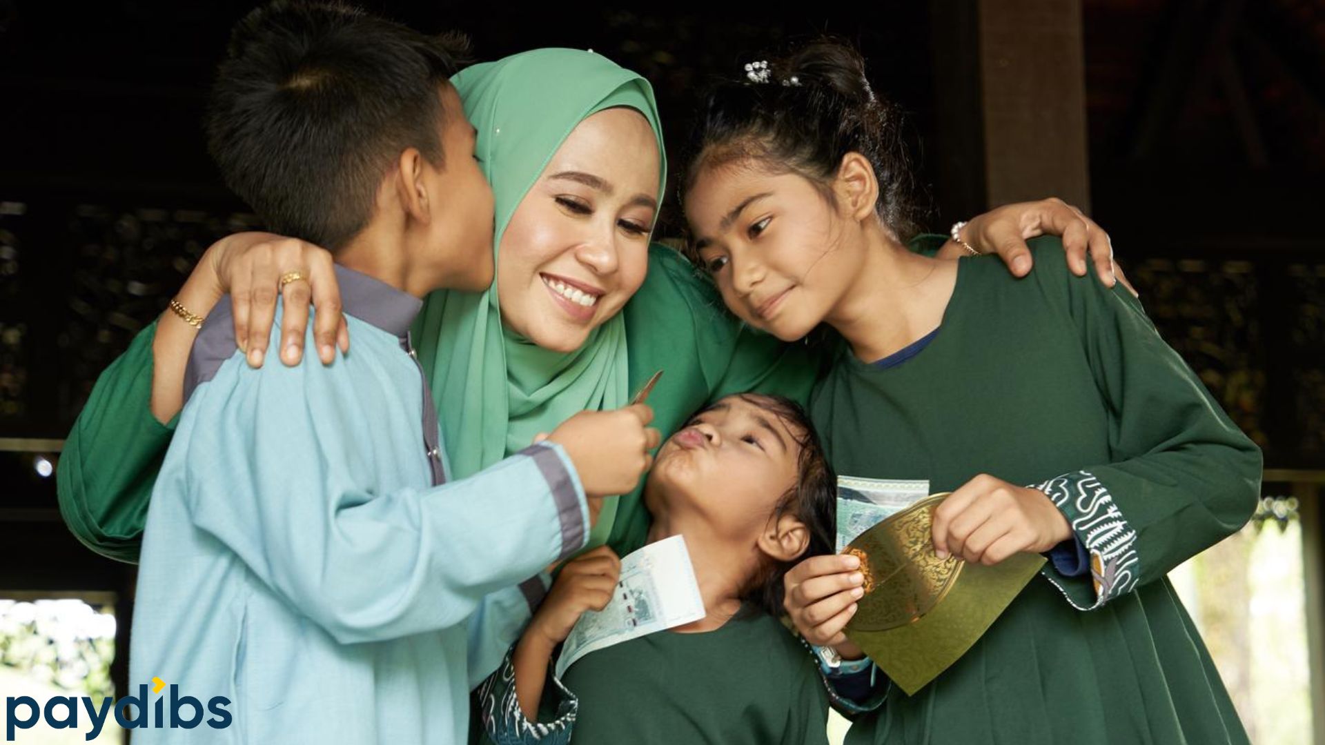 Malay family celebrating Hari Raya and giving out duit raya