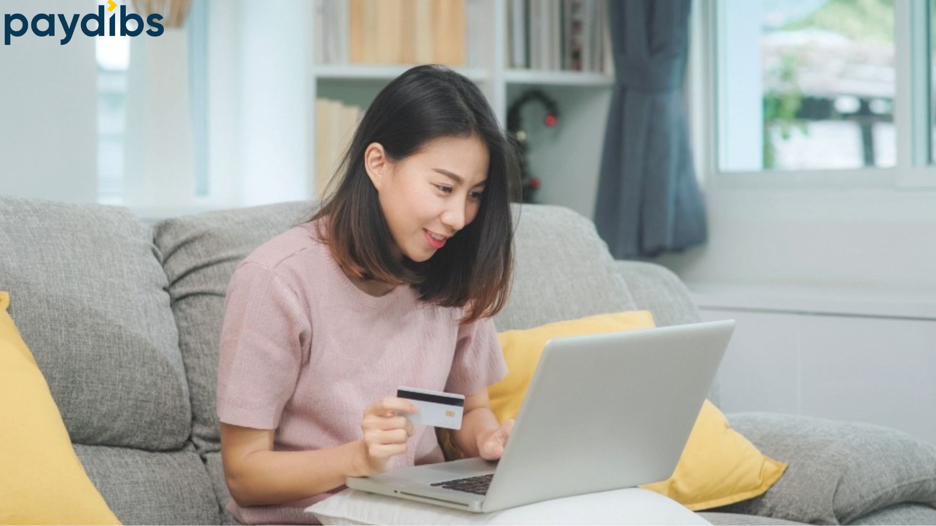 A woman holding card checking the swift code of bank online at Paydibs